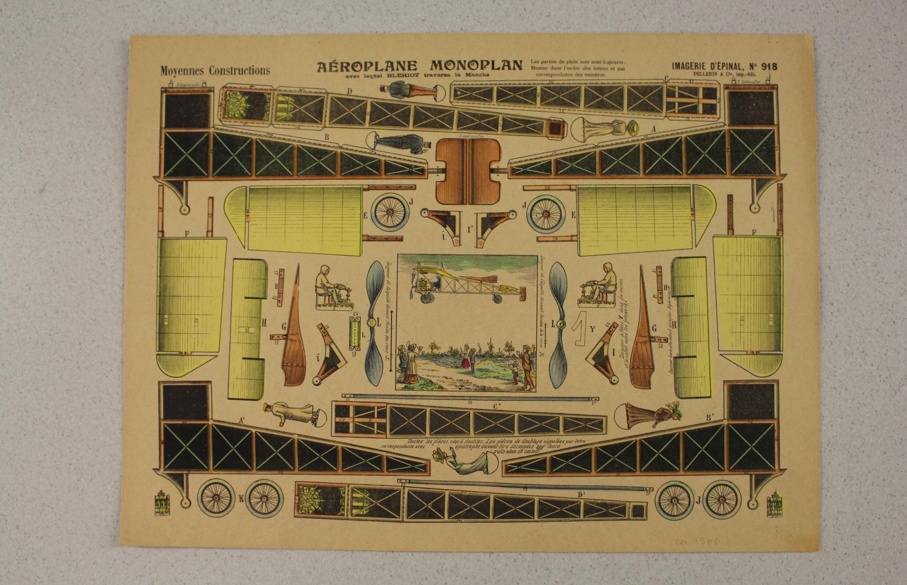 Der Aussschneidebogen Aéroplane Monoplan No 918 in Frontansicht. Einzelne Teile des Flugzeugs sind farbig aufgezeichnet.