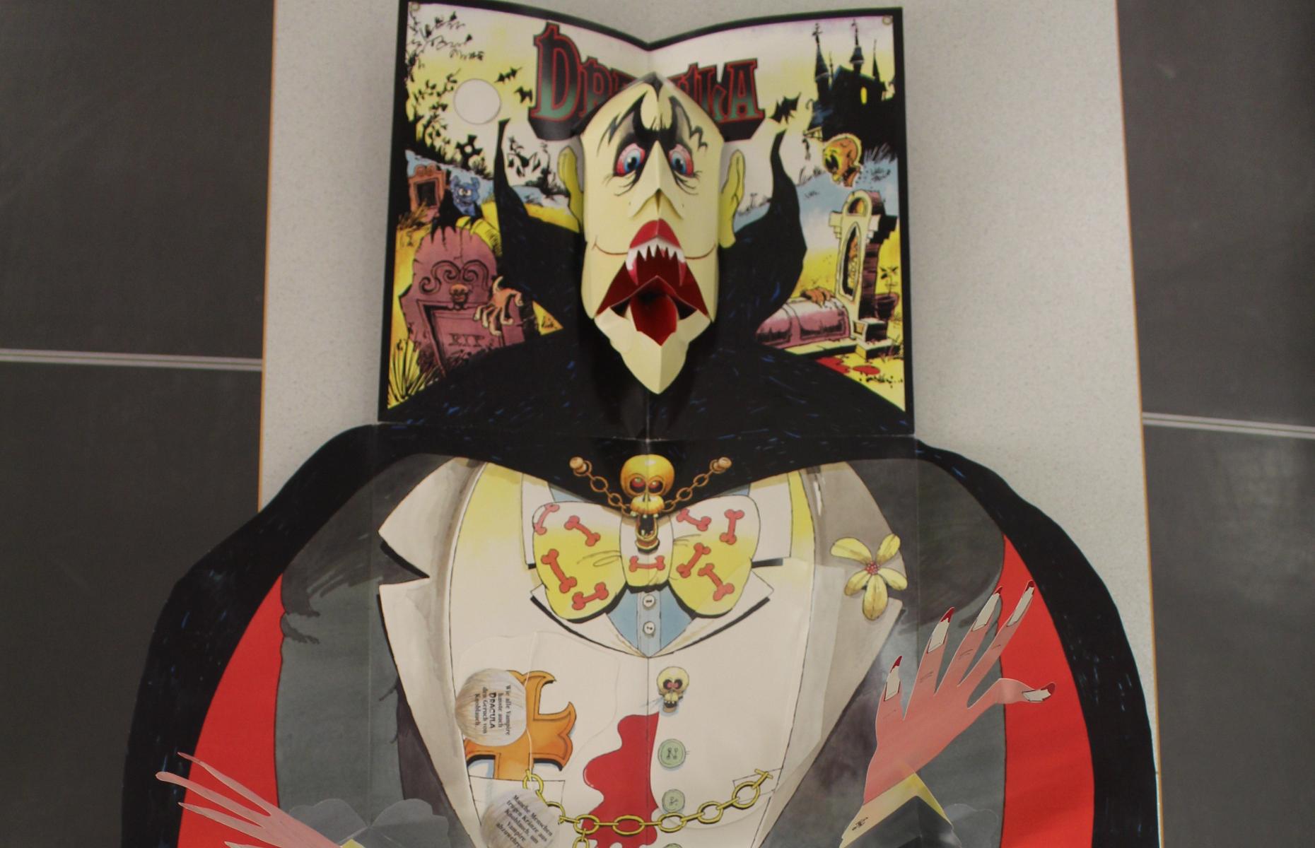 Oberer Teil des vollständig aufgeklappten Pop-up-Buch "Graf Dracula". Zu sehen sind der Kopf und die Arme von Graf Dracula.