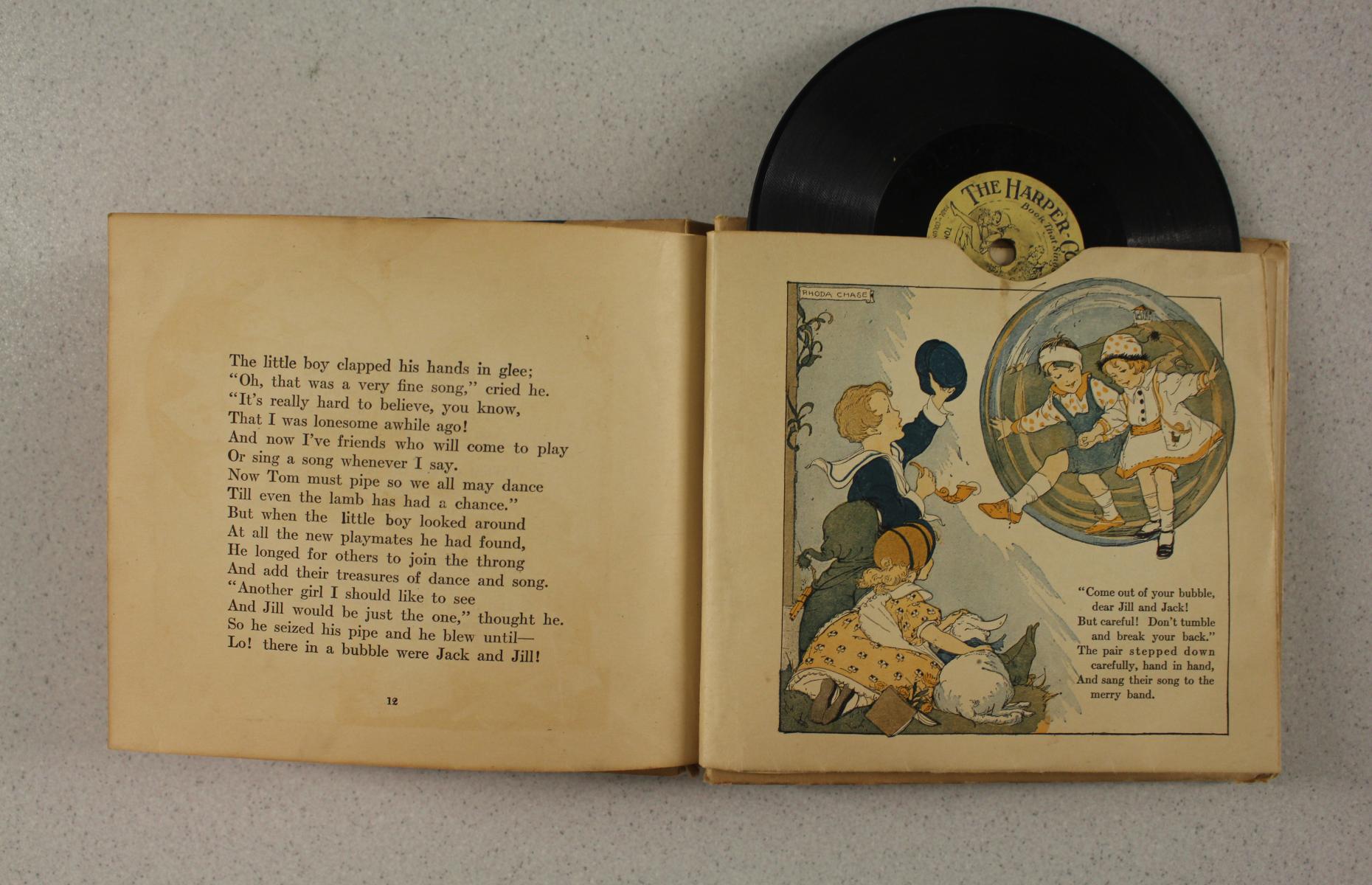 Eine Doppelseite im Buch. Auf der ersten Seite ist Text und auf der zweiten Seite befindet sich eine Illustration. Oben lugt eine Schelllackplatte heraus.