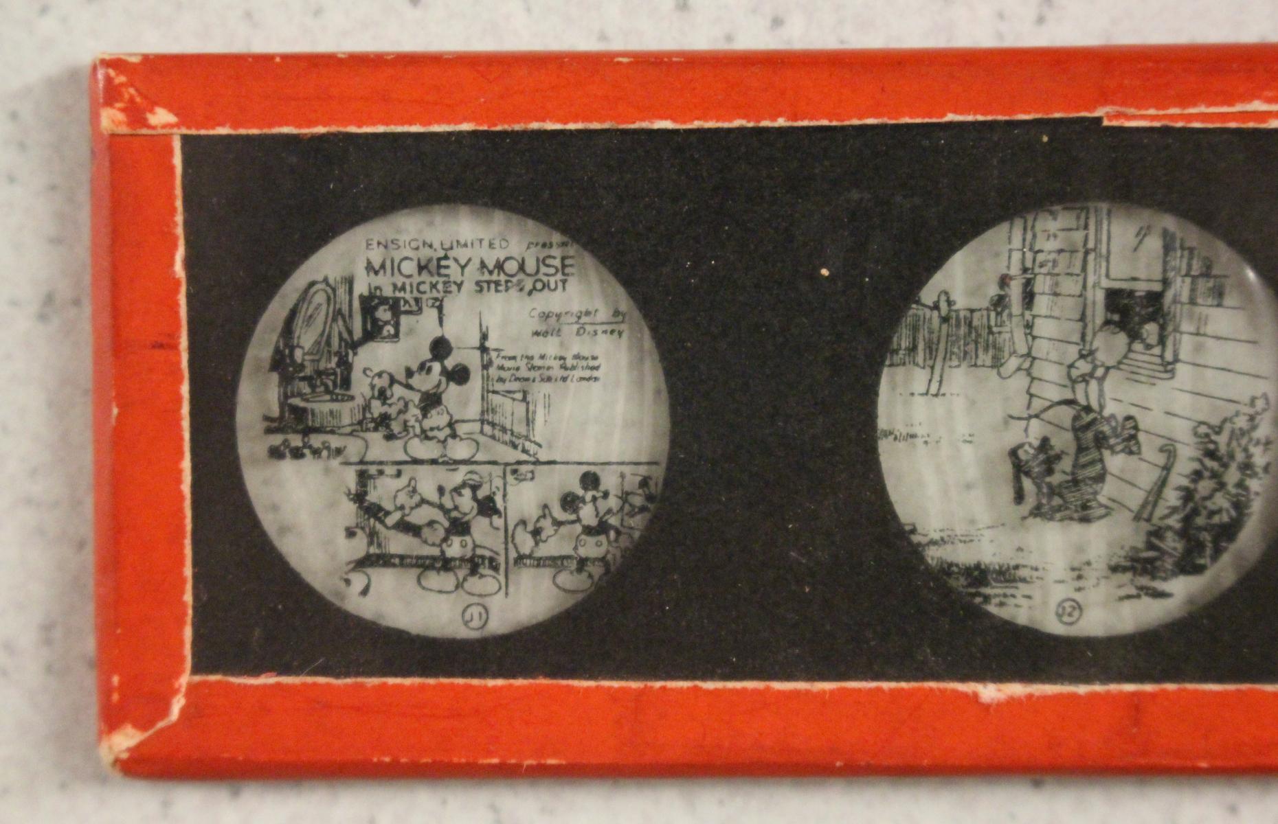 Nahaufnahme einer der Mickey Mouse Glasdurchziehbilder. Die Szene zeigt Mickey Mouse beim Arbeiten.