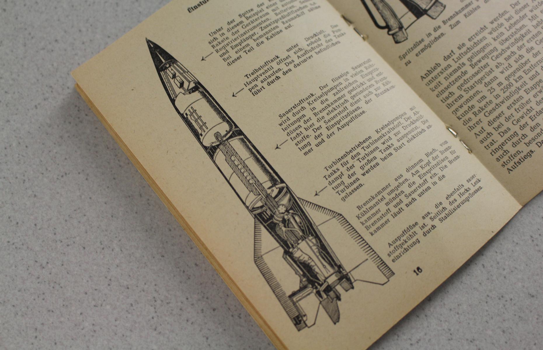 Das Bild zeigt eine Seite des Hefts in Frontalansicht. Die linke Hälfte der Seite wird von der Karikatur einer Rakete eingenommen.